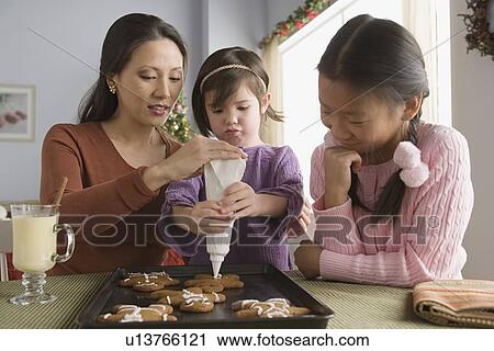 Mother and daughters (10-11) preparing cakes View Large Photo Image Stock Image - Mother and daughters (10-11) preparing cakes. Fotosearch