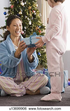 Mother giving daughter (10-11) christmas gifts View Large Photo Image Stock Photograph - Mother giving daughter (10-11) christmas gifts. Fotosearch