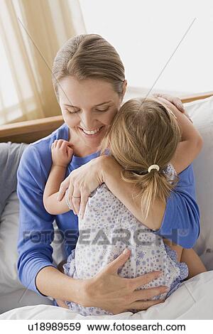 Stock Photo - Mother hugging daughter. Fotosearch