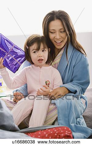 Mother with daughter unwrapping christmas gifts View Large Photo Image Stock Photo - Mother with daughter unwrapping christmas gifts. Fotosearch