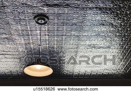 Stock Photograph - Pendant lamp on tiled ceiling. Fotosearch