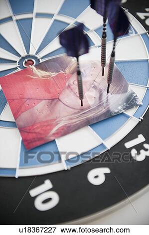 Stock Photo - Photograph of woman stuck with darts. Fotosearch