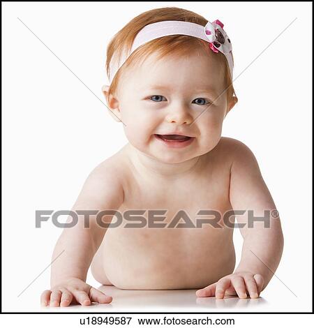 Stock Photo - Portrait of baby girl (6-11 months) smiling, studio shot. Fotosearch