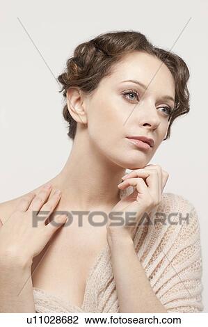 Stock Image - Portrait of beautiful young woman, studio shot. Fotosearch