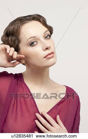 Stock Image - Portrait of beautiful young woman, studio shot. Fotosearch