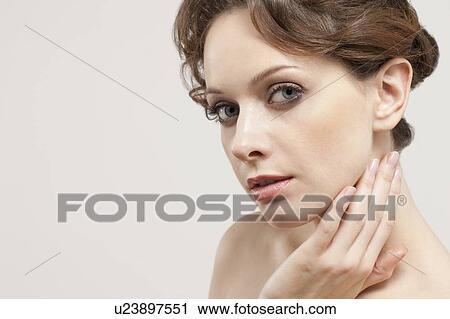 Stock Image - Portrait of beautiful young woman, studio shot. Fotosearch