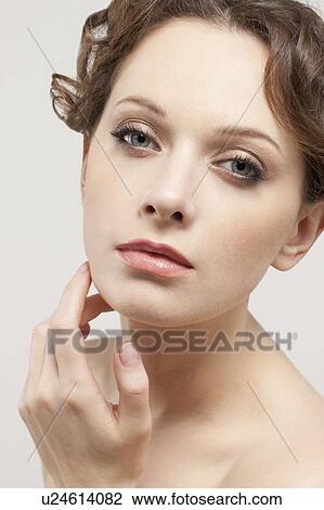 Stock Image - Portrait of beautiful young woman, studio shot. Fotosearch