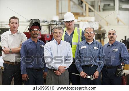 Stock Photograph - Portrait of businessman and workers in factory. Fotosearch