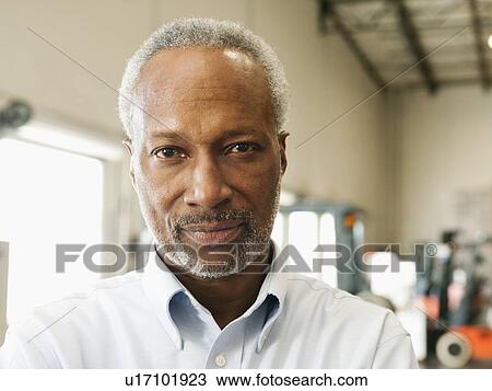 Stock Image - Portrait of businessman in warehouse. Fotosearch