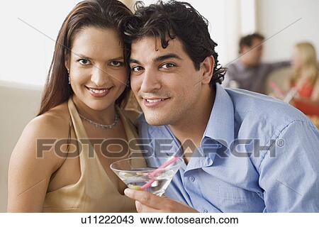 Stock Image - Portrait of couple at party, people in background. Fotosearch