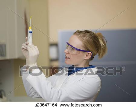 Picture - Portrait of dentist holding dental tools. Fotosearch