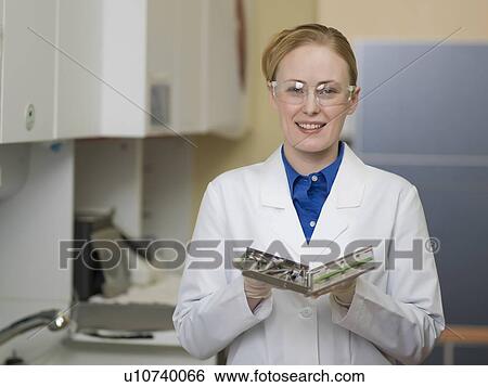 Stock Photograph - Portrait of dentist holding dental tools. Fotosearch