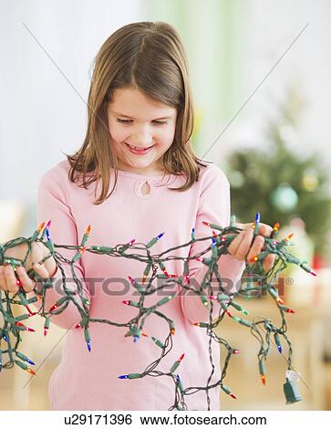 Portrait of girl (8-9) with christmas lights View Large Photo Image Stock Photograph - Portrait of girl (8-9) with christmas lights. Fotosearch