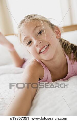 Portrait of girl lying on bed View Large Photo Image Stock Image - Portrait of girl lying on bed. Fotosearch