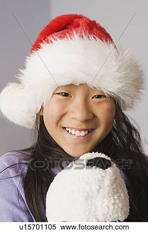 Stock Photography - Portrait of girl wearing santa hat. Fotosearch