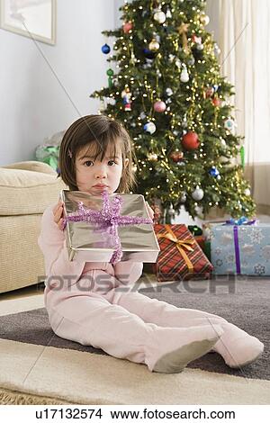 Picture - Portrait of girl with presents at Christmas morning. Fotosearch