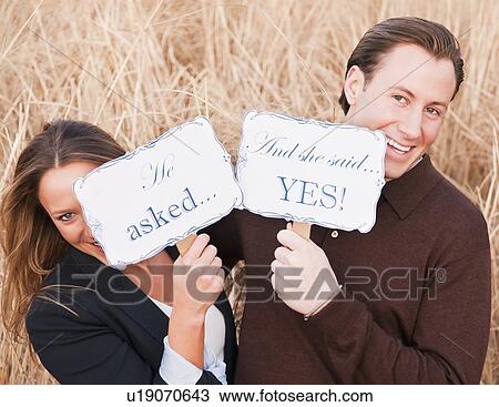 Stock Image - Portrait of happy young couple on wheat field. Fotosearch