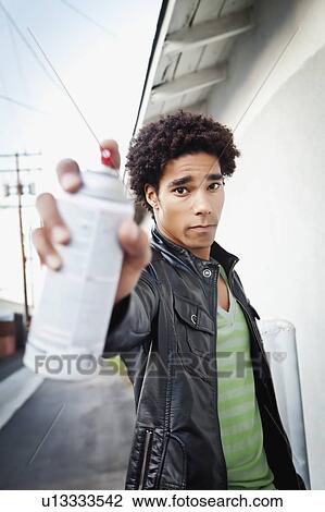 Portrait of man holding spray paint View Large Photo Image Stock Image - Portrait of man holding spray paint. Fotosearch