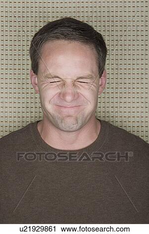 Stock Image - Portrait of man with eyes closed and funny face. Fotosearch