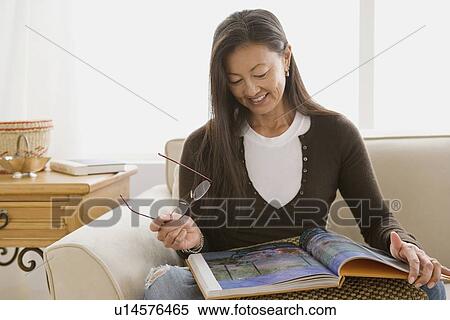 Stock Photography - Portrait of mature woman reading book. Fotosearch