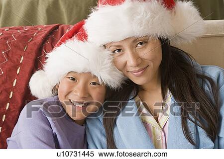 Portrait of mother and daughter (10-11) wearing Santa hats View Large Photo Image Stock Photography - Portrait of mother and daughter (10-11) wearing Santa hats. Fotosearch