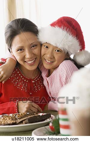 Stock Photography - Portrait of mother and daughter enjoying christmas meal. Fotosearch