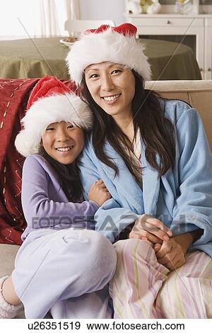 Portrait of mother and daughter wearing Santa hats View Large Photo Image Stock Photo - Portrait of mother and daughter wearing Santa hats. Fotosearch