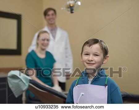 Stock Photography - Portrait of patient, dentists in background. Fotosearch