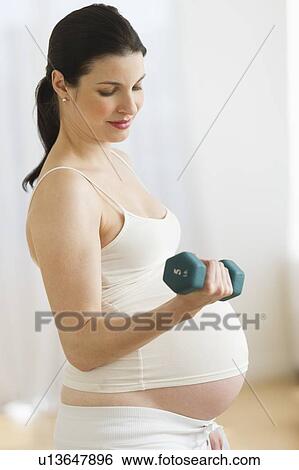 Stock Photograph - Portrait of pregnant woman exercising. Fotosearch
