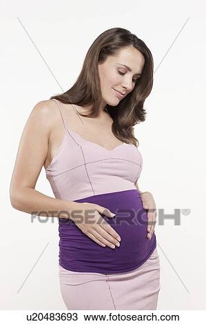 Portrait of pregnant woman in pink dress, studio shot View Large Photo Image Stock Image - Portrait of pregnant woman in pink dress, studio shot. Fotosearch