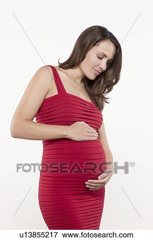 Portrait of pregnant woman in red dress, studio shot View Large Photo Image Stock Photo - Portrait of pregnant woman in red dress, studio shot. Fotosearch