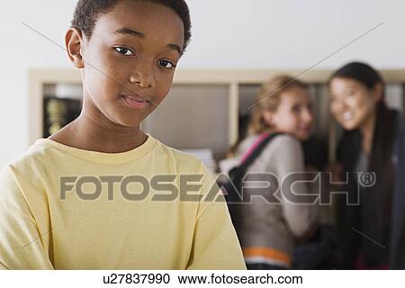Portrait of schoolboy with two gild gossiping in background View Large Photo Image Stock Image - Portrait of schoolboy with two gild gossiping in background. Fotosearch