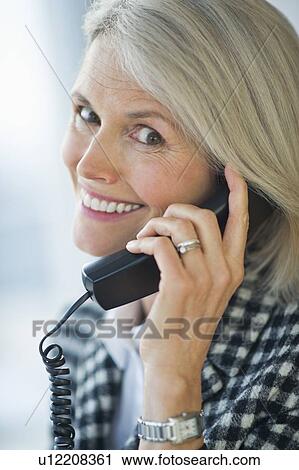 Stock Image - Portrait of senior businesswoman talking on phone. Fotosearch