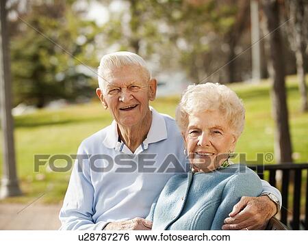 Stock Photograph - Portrait of senior couple on park bench. Fotosearch