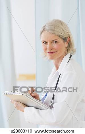 Portrait of senior female doctor working in her office View Large Photo Image Stock Image - Portrait of senior female doctor working in her office. Fotosearch