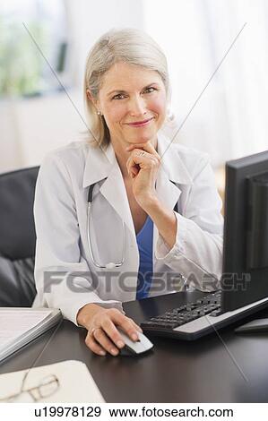 Stock Photo - Portrait of senior female doctor working in her office. Fotosearch