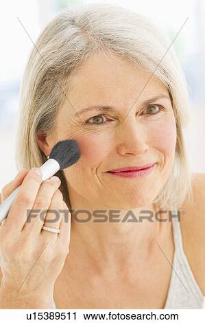Portrait of senior woman applying blush View Large Photo Image Stock Image - Portrait of senior woman applying blush. Fotosearch