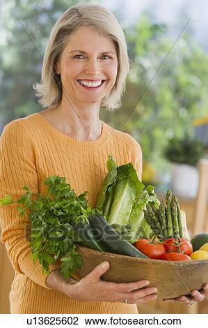 Portrait of senior woman carrying bowl with vegetables View Large Photo Image Stock Image - Portrait of senior woman carrying bowl with vegetables. Fotosearch
