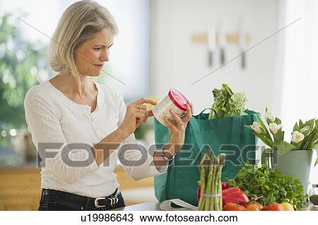 Portrait of senior woman checking product in kitchen View Large Photo Image Stock Image - Portrait of senior woman checking product in kitchen. Fotosearch