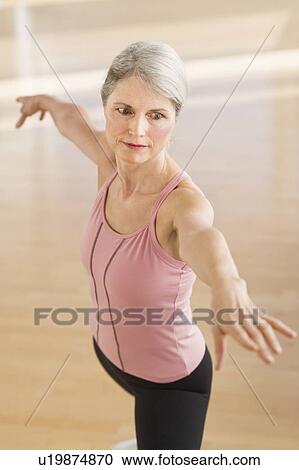 Stock Image - Portrait of senior woman exercising in gym. Fotosearch