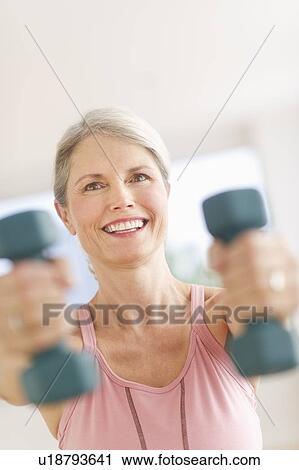 Portrait of senior woman exercising with dumbbells in gym View Large Photo Image Stock Image - Portrait of senior woman exercising with dumbbells in gym. Fotosearch