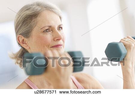 Portrait of senior woman exercising with dumbbells in gym View Large Photo Image Stock Image - Portrait of senior woman exercising with dumbbells in gym. Fotosearch