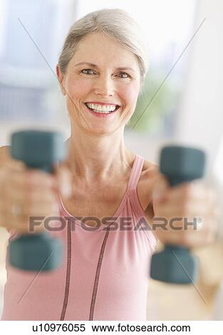 Portrait of senior woman exercising with dumbbells in gym View Large Photo Image Stock Photography - Portrait of senior woman exercising with dumbbells in gym. Fotosearch
