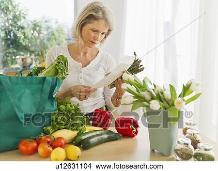 Portrait of senior woman with shopping bag in kitchen View Large Photo Image Picture - Portrait of senior woman with shopping bag in kitchen. Fotosearch