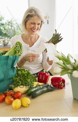Portrait of senior woman with shopping bag in kitchen View Large Photo Image Stock Image - Portrait of senior woman with shopping bag in kitchen. Fotosearch