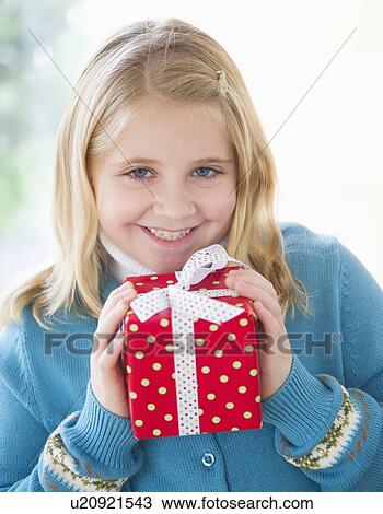 Portrait of smiling girl (8-9) holding gift View Large Photo Image Stock Image - Portrait of smiling girl (8-9) holding gift. Fotosearch