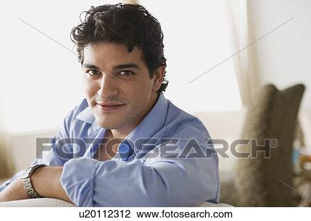 Stock Image - Portrait of smiling man at home. Fotosearch