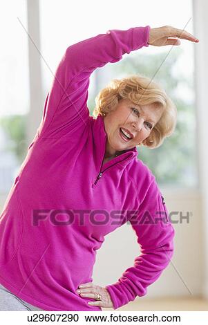 Stock Image - Portrait of smiling senior woman stretching. Fotosearch