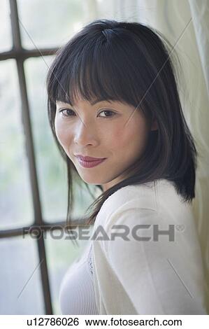 Stock Photograph - Portrait of smiling woman looking at camera. Fotosearch