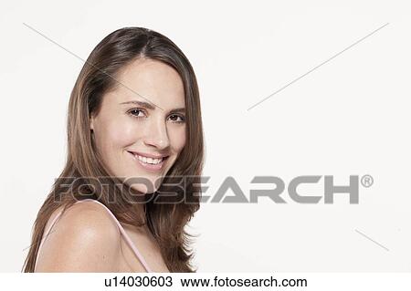 Stock Image - Portrait of smiling woman, studio shot. Fotosearch